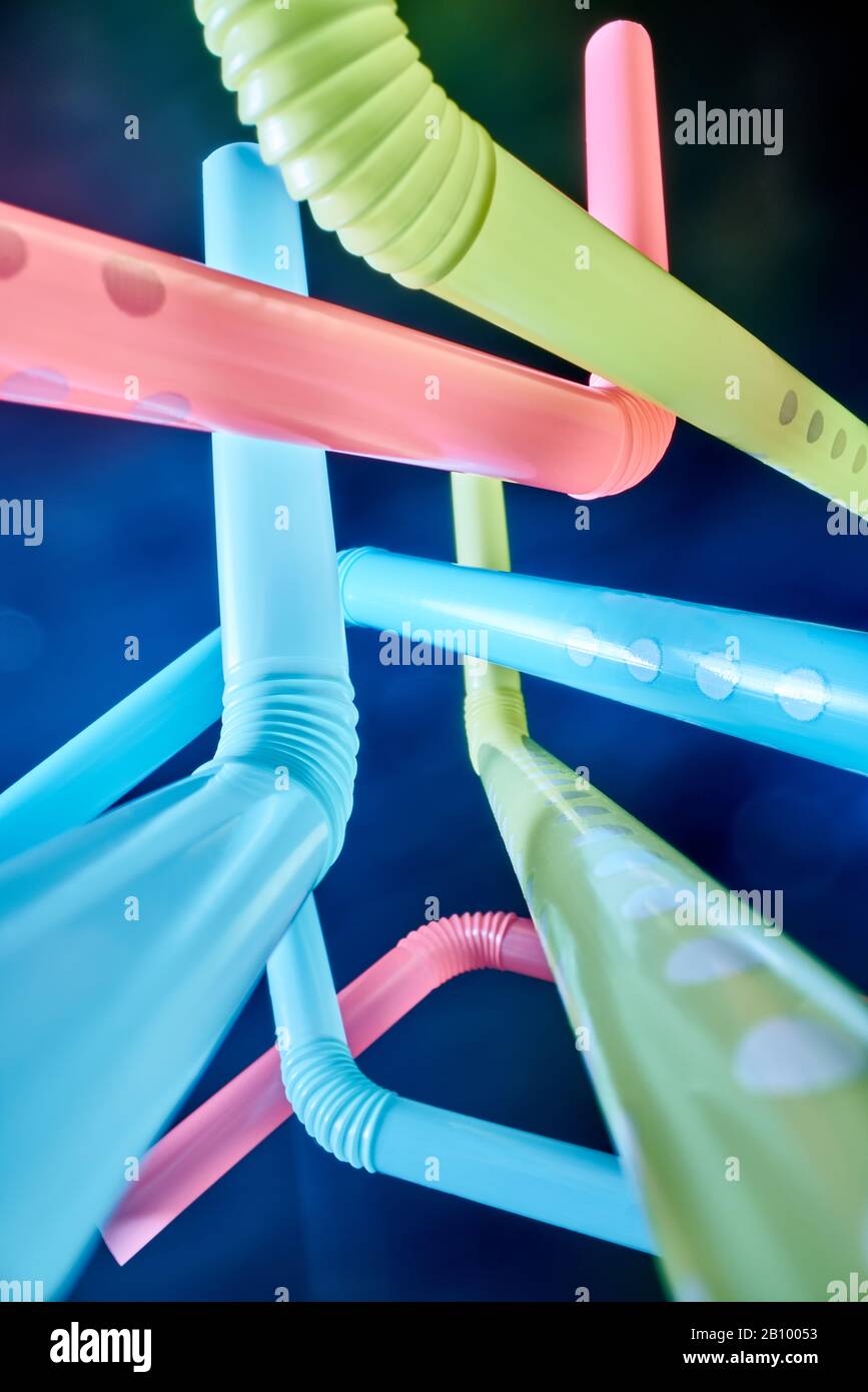 Background from multi-colored plastic cocktail tubes on a dark background Stock Photo