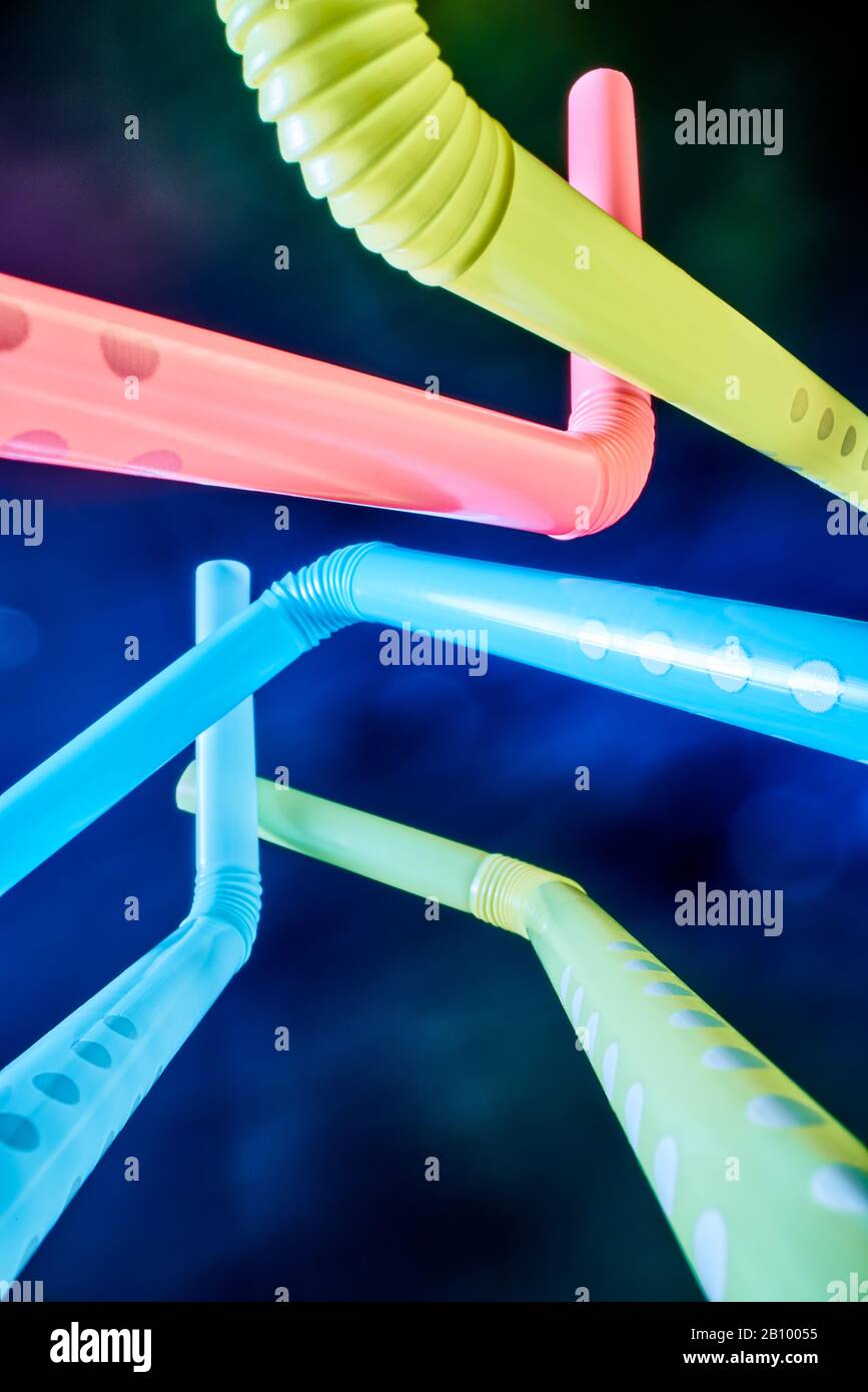 Background from multi-colored plastic cocktail tubes on a dark background Stock Photo