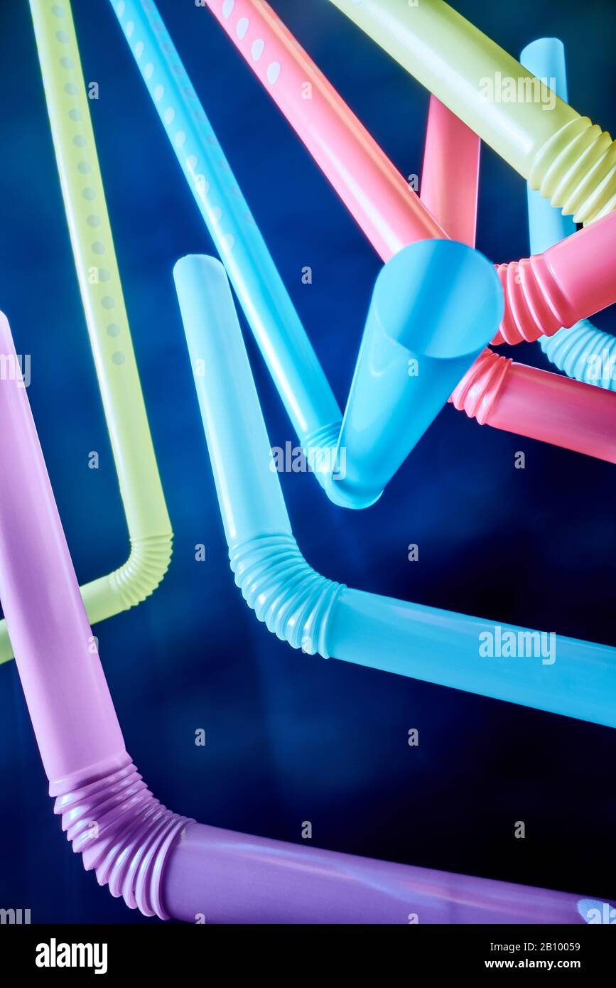 Background from multi-colored plastic cocktail tubes on a dark background Stock Photo