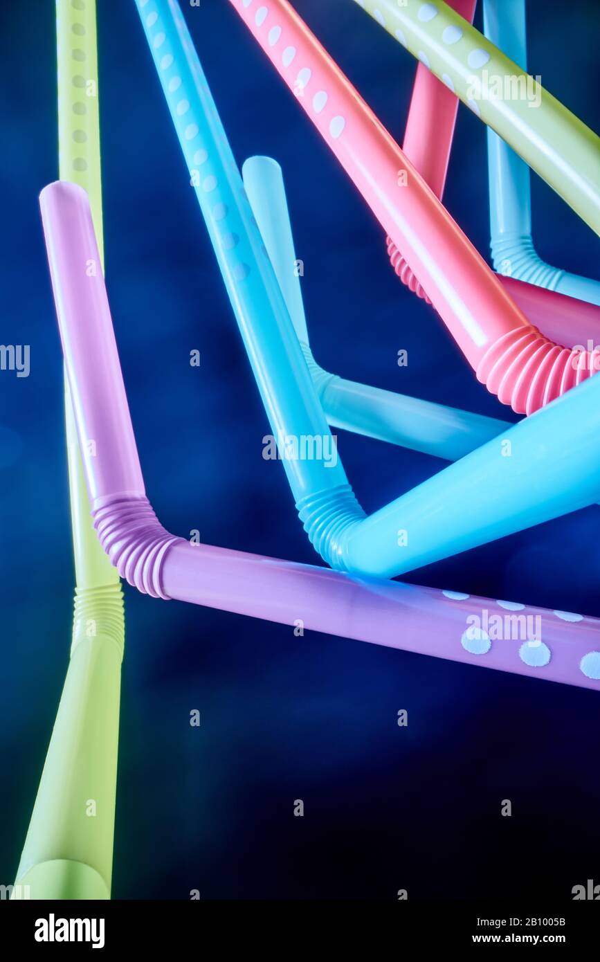 Background from multi-colored plastic cocktail tubes on a dark background Stock Photo