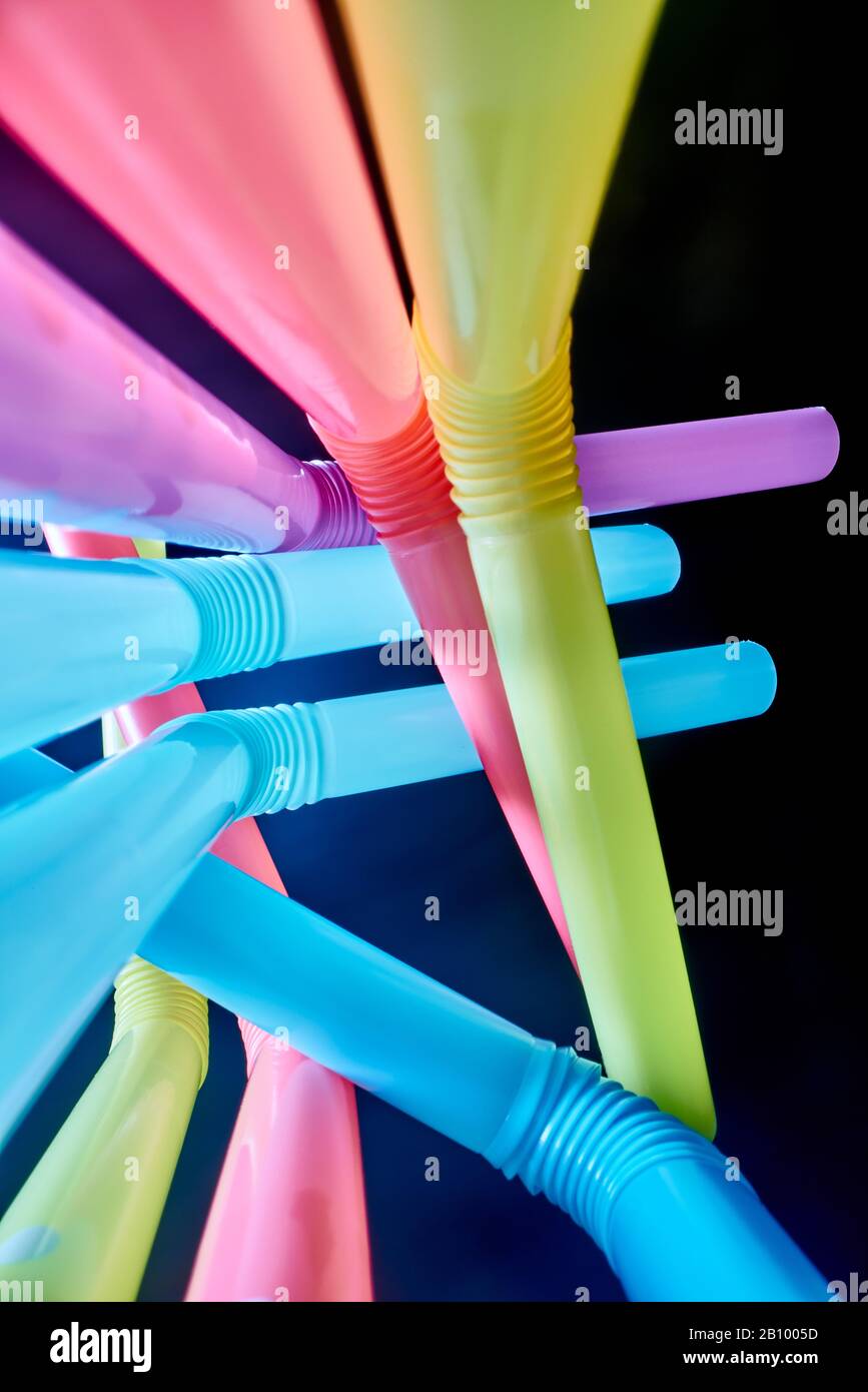 Background from multi-colored plastic cocktail tubes on a dark background Stock Photo