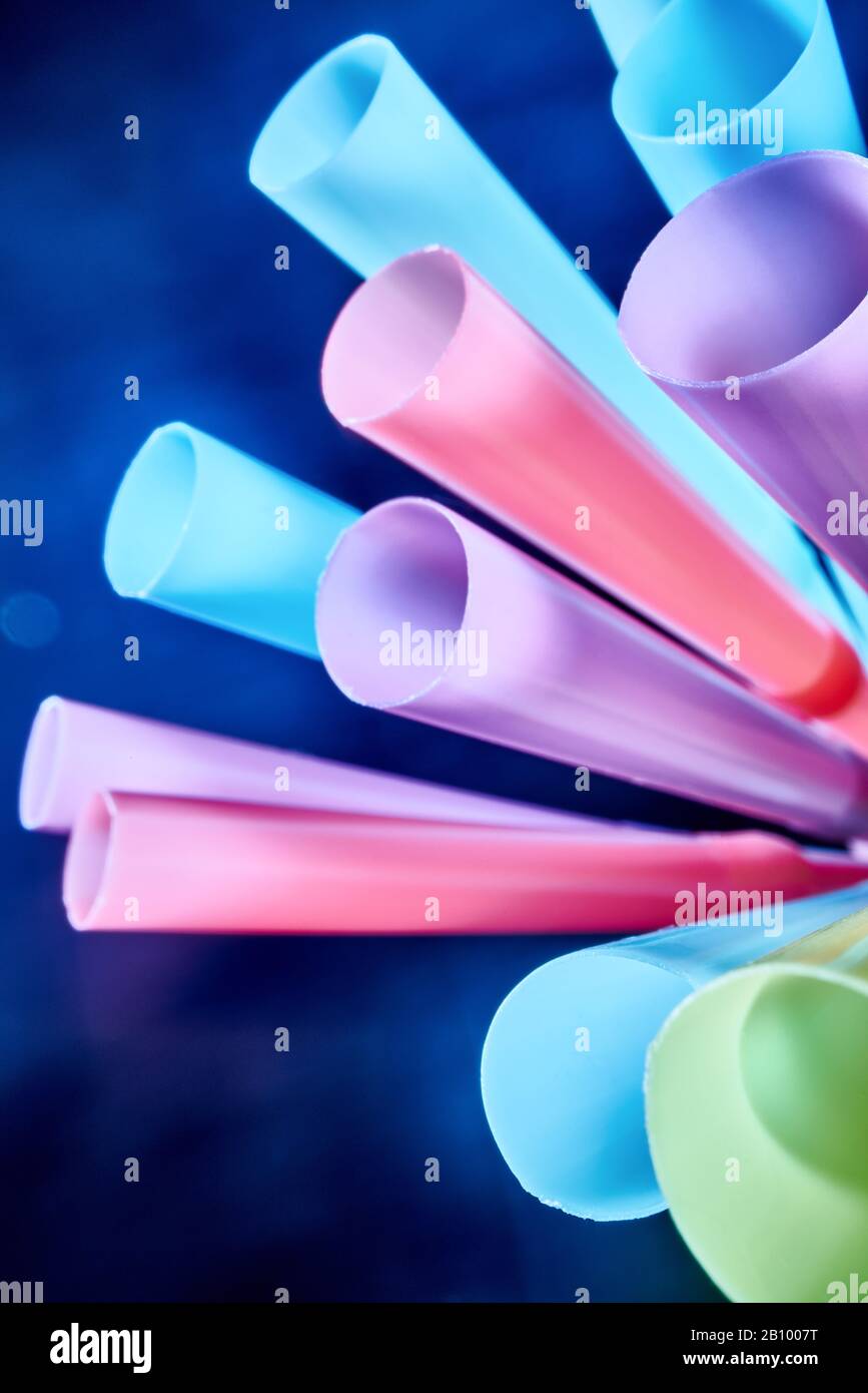 Background from multi-colored plastic cocktail tubes on a dark background Stock Photo