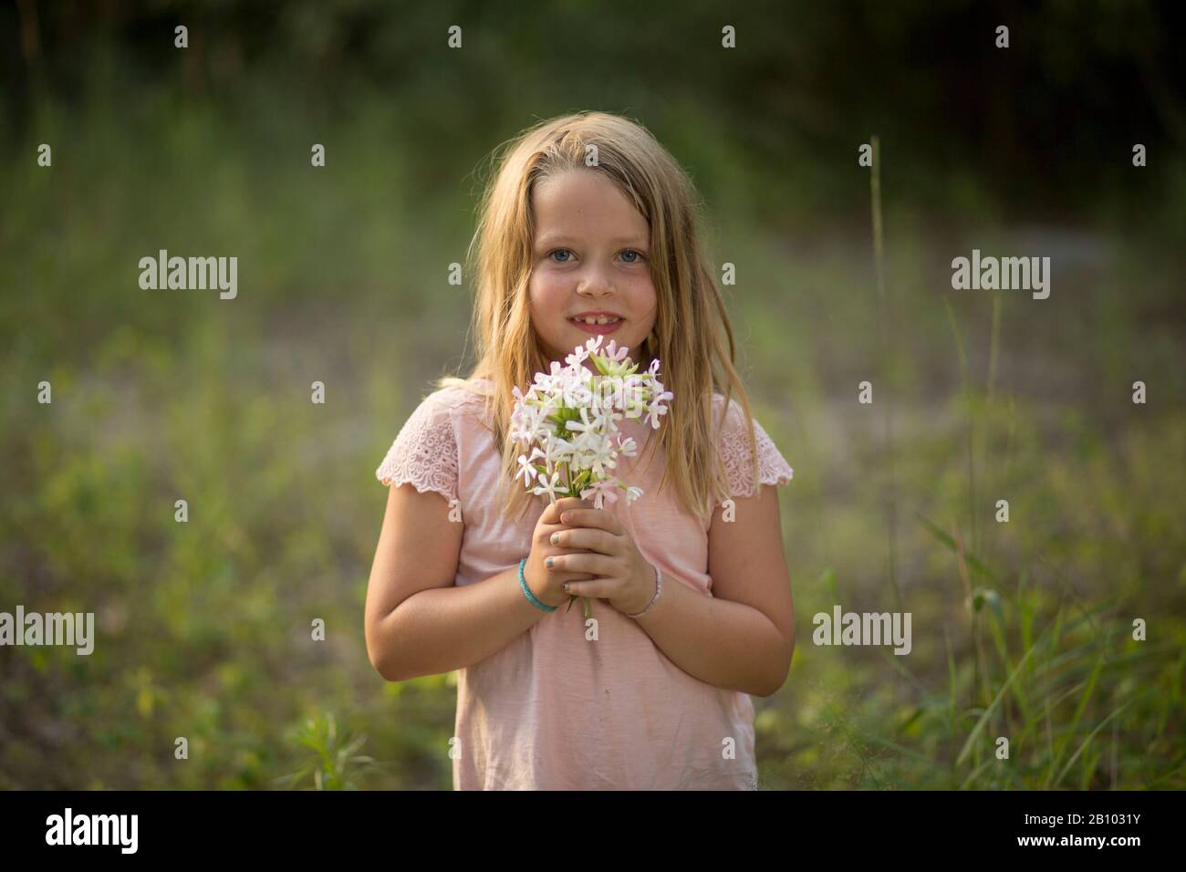 Little girl with bouquet in the forest Stock Photo