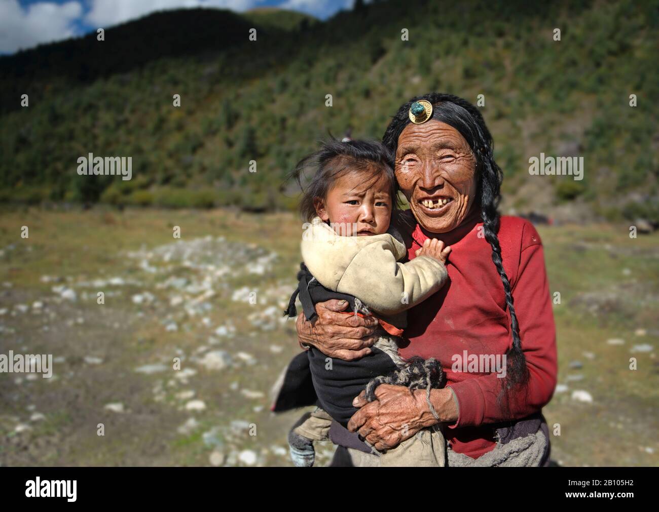 Tibetan families stick together. While parents work, grandparents are in charge of looking after their grandchildren. Remote Tibetan plateau Stock Photo