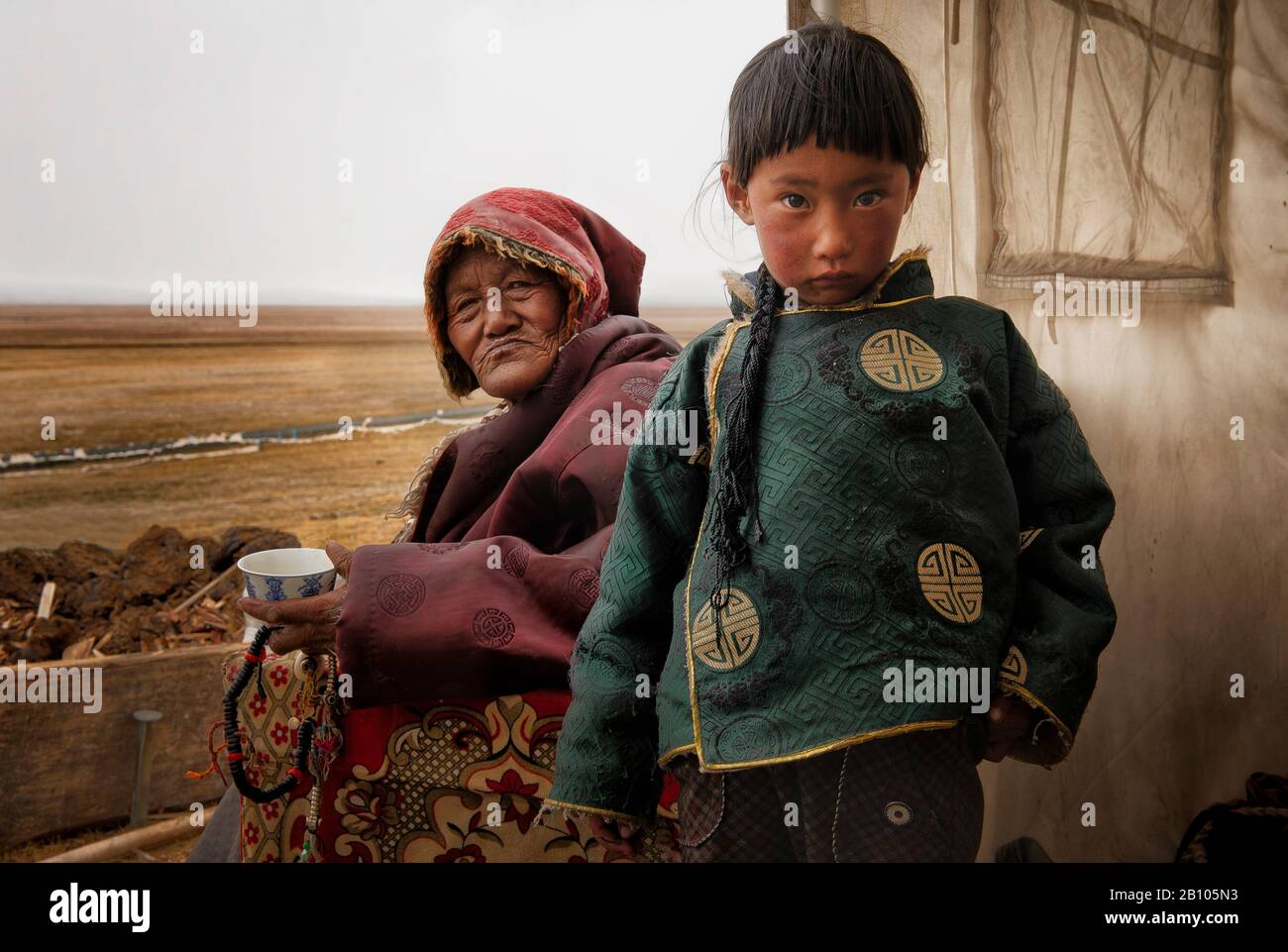 Tibetan families stick together. While parents work in the fields herding yaks, grandparents are in charge of looking after their grandchildren. Remote Tibetan plateau Stock Photo