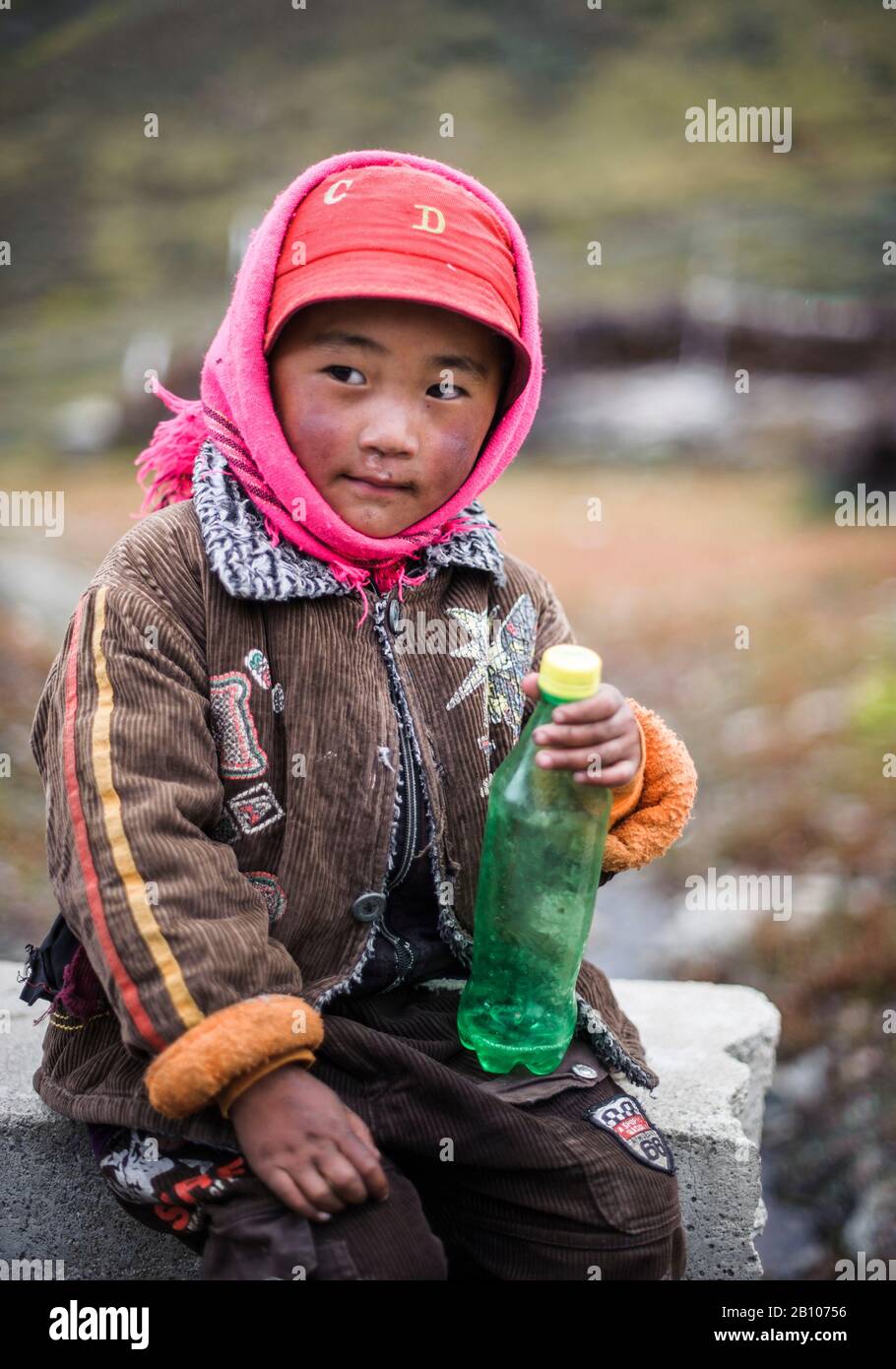 Portrait of a Tibetan child with cheeks flushed by the harsh weather and cold, typical feature of the Tibetan people, Kham province, highlands of Tibet Stock Photo