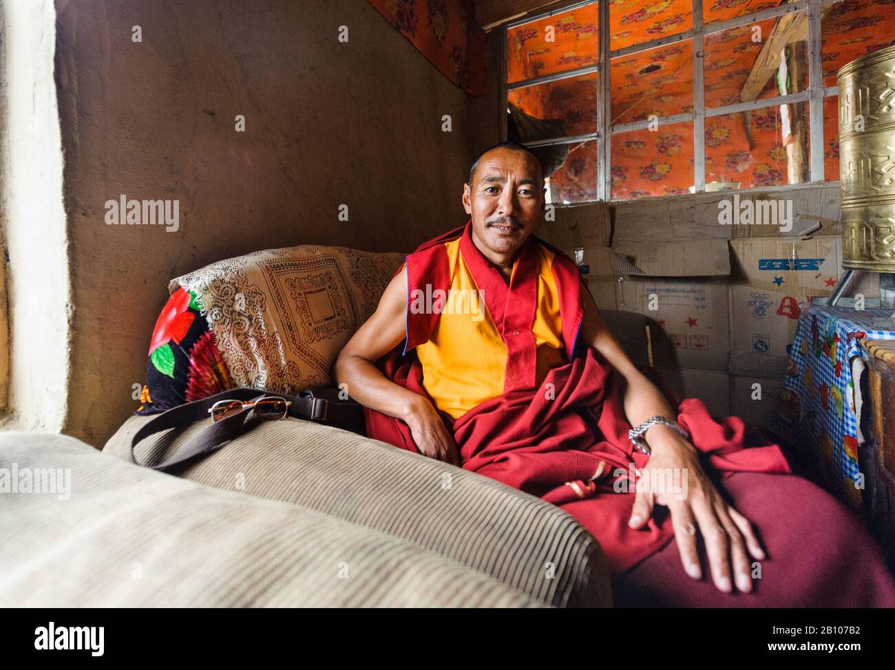 Buddhist monk sitting in an armchair, Tibetan plateau Stock Photo - Alamy