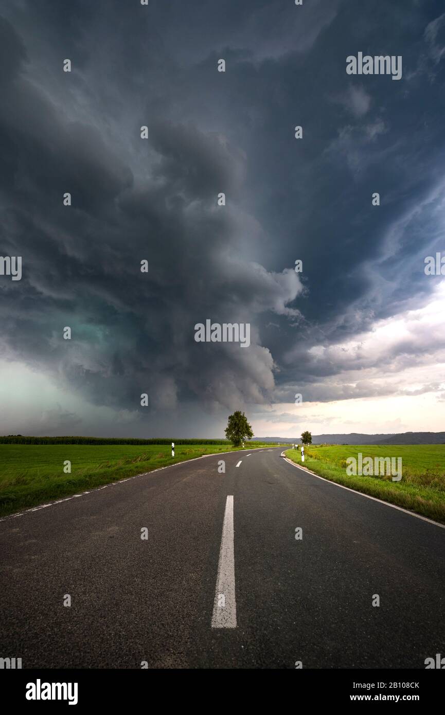 Shimmering green precipitation core of a supercell with street in the foreground near Altdorf near Nuremberg, Bavaria, Germany Stock Photo