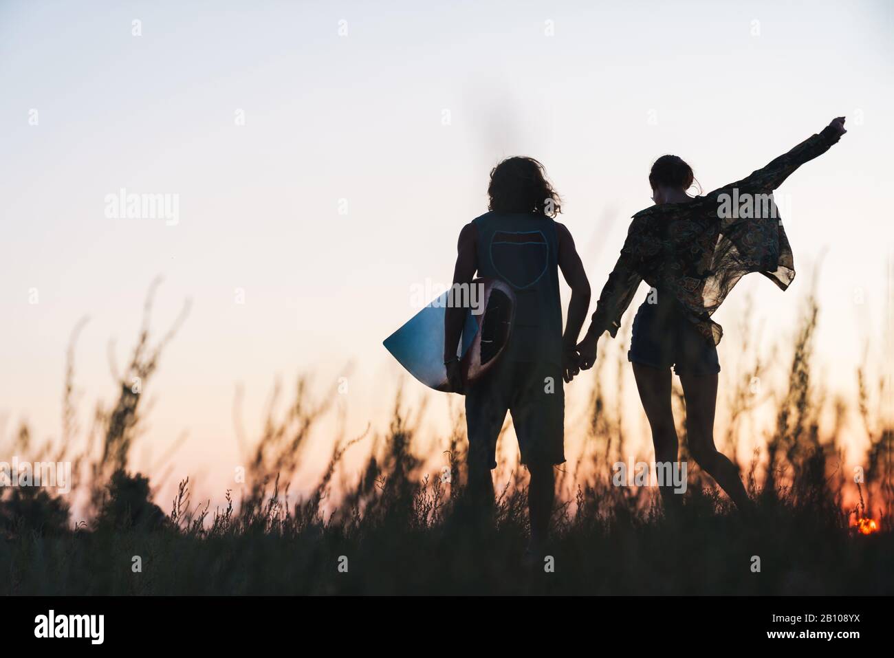 Surfer couple holding hands hi-res stock photography and images - Alamy