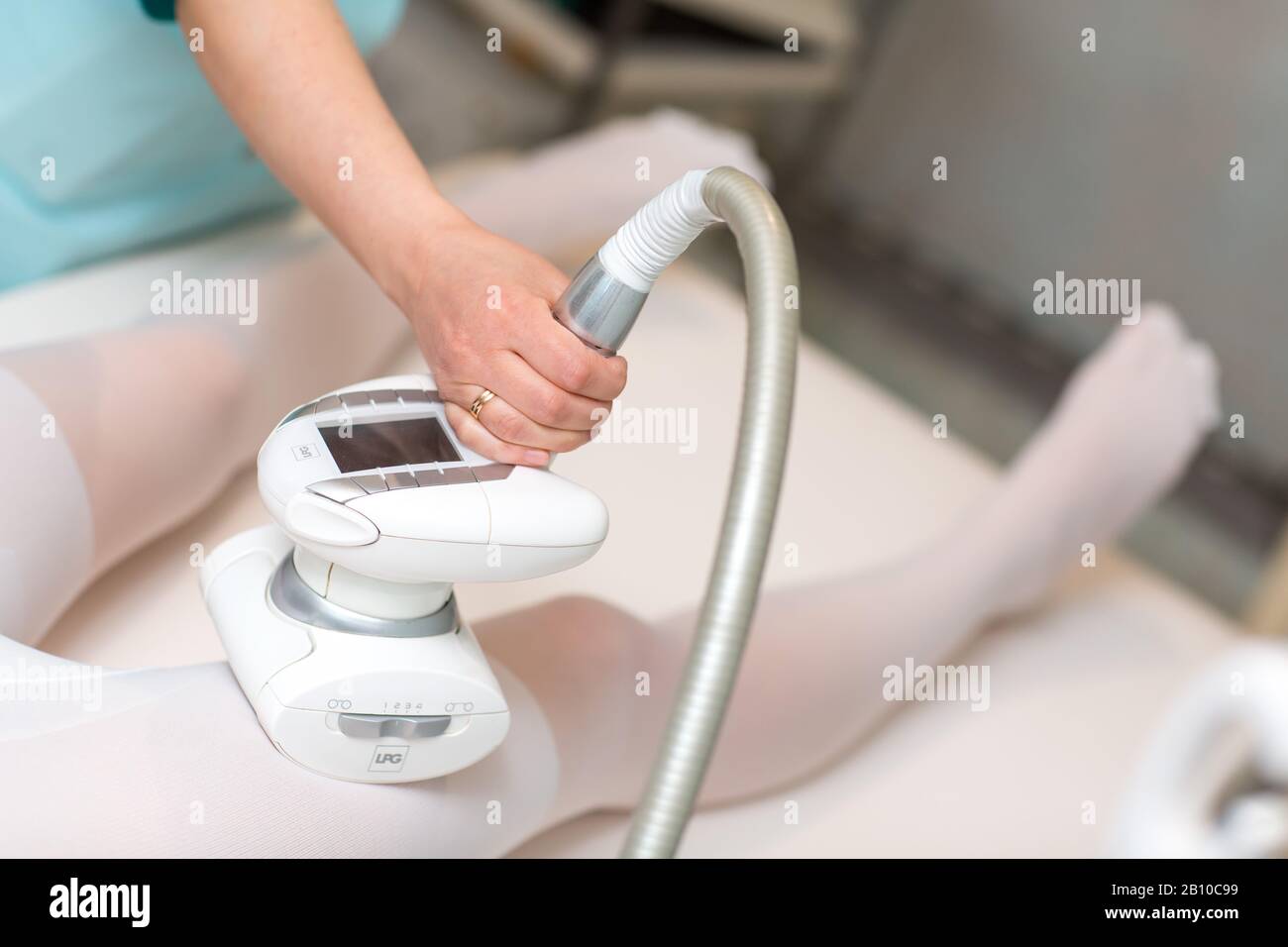 Young beautiful woman and LPG massage procedure in spa clinic. Lymphatic drainage massage LPG apparatus process. Stock Photo