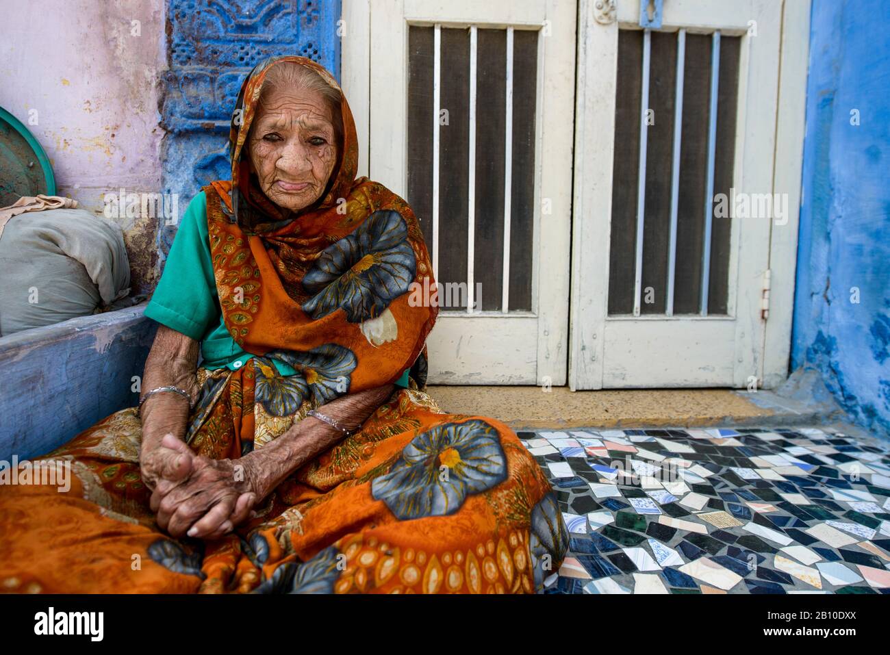 Old woman sitting on the floor outside her house, Jodhpur, India Stock Photo