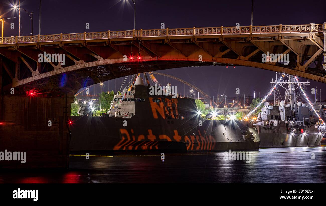 USS Independence LCS-2  ship at night during Rose Festival. A phrase 'no Dictatorship' projected on a side of a ship Stock Photo