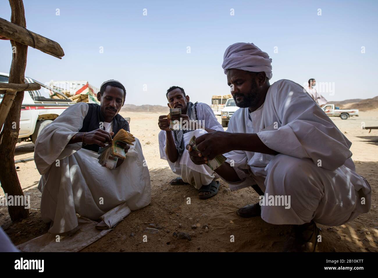 Sudanese men of the Sahara count money from the sale of field beans, Sudan Stock Photo