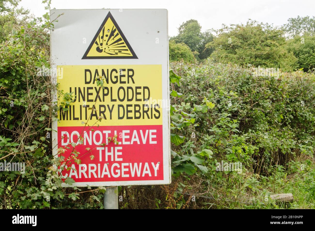Sign beside a road on Salisbury Plain warning of unexploded ordnance.  The area is usually closed to visitors and is used by the British Army for trai Stock Photo