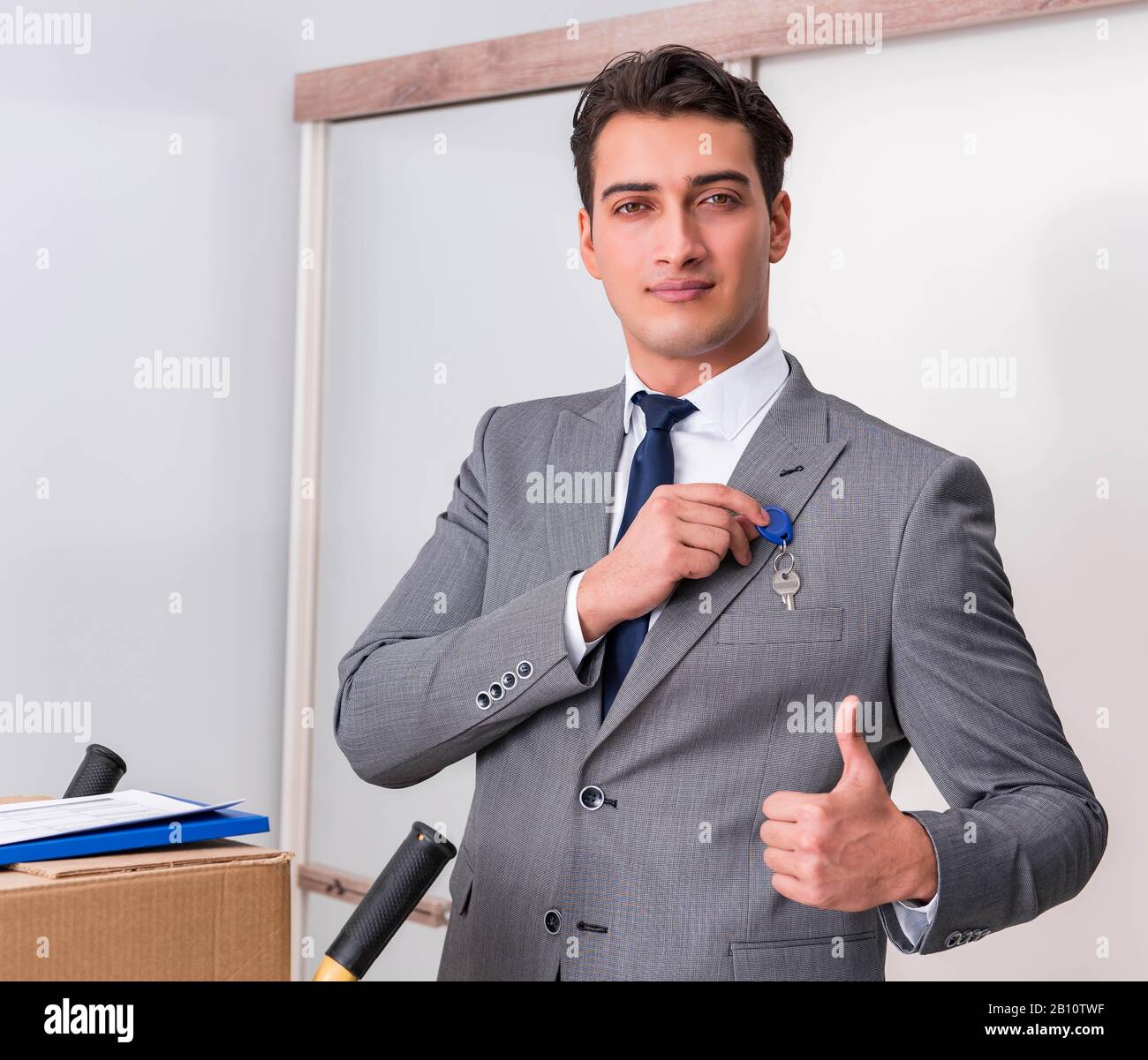 The businessman in real estate concept with home key Stock Photo - Alamy