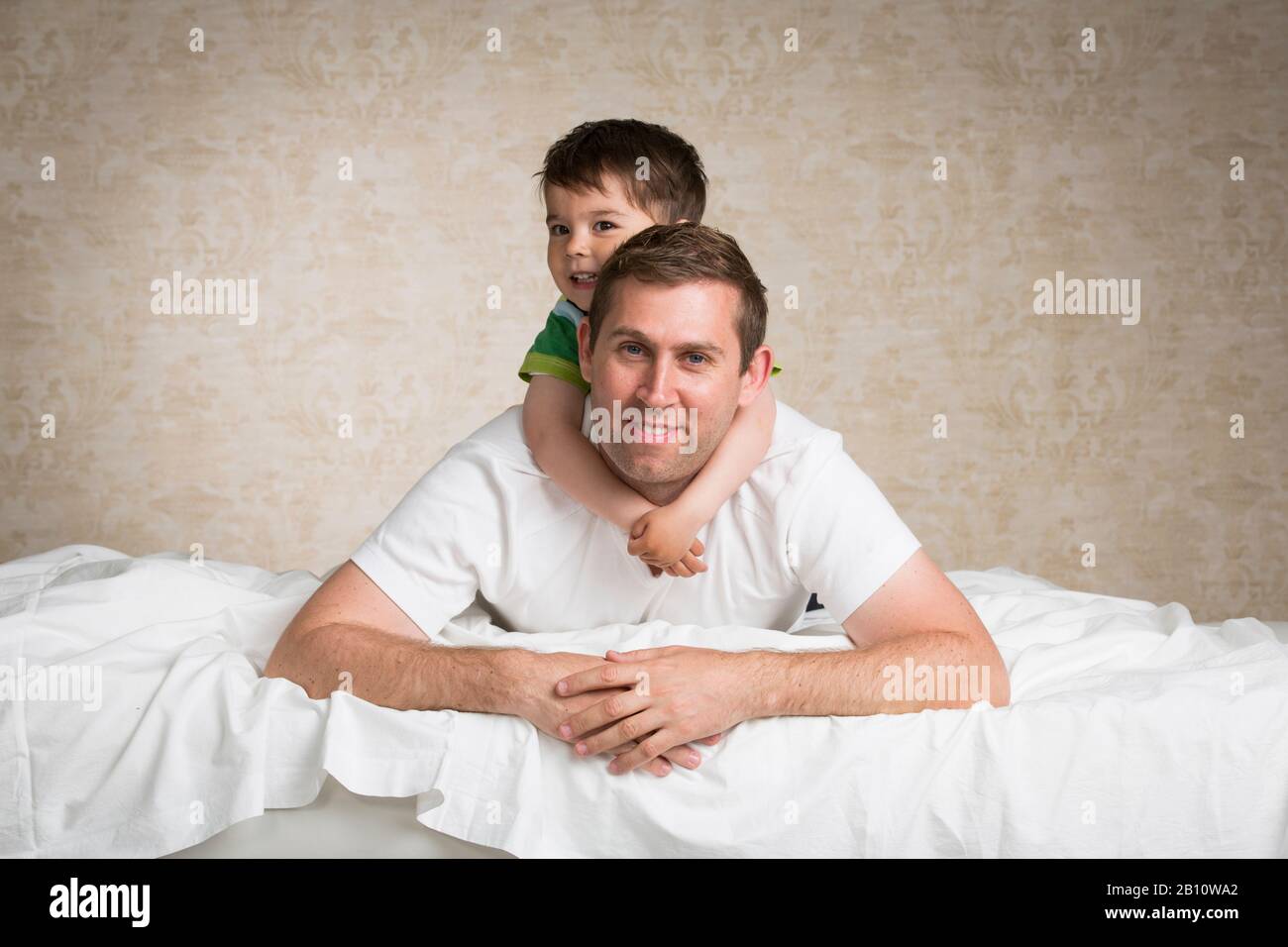 Father and son lie on a bed Stock Photo