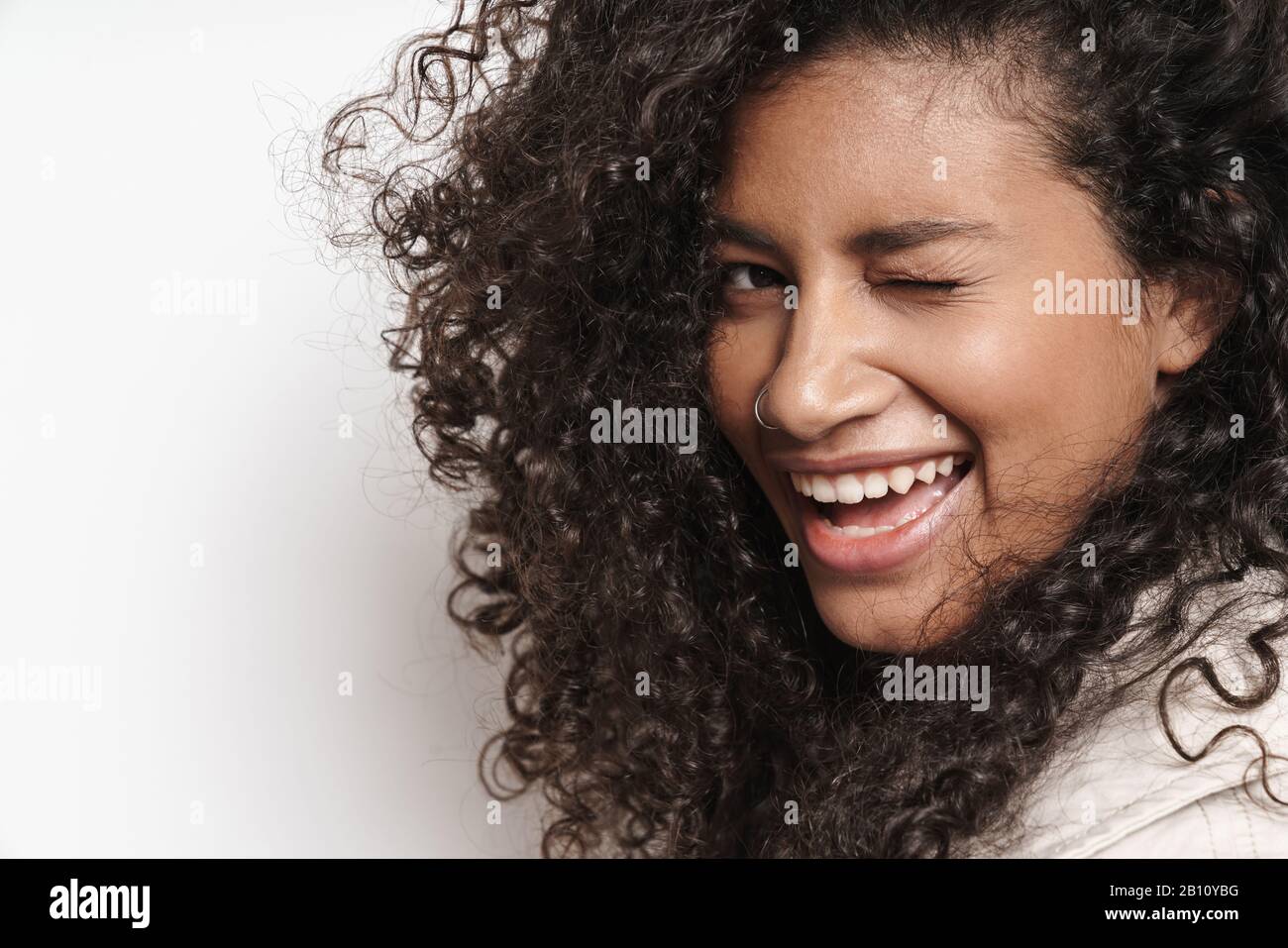 Close up of a beautiful smiling young african woman standing isolated ...
