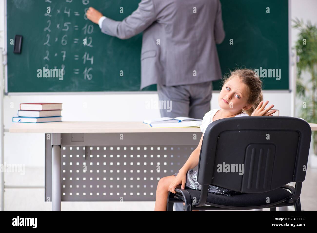 The teacher with young girl in the classroom Stock Photo - Alamy
