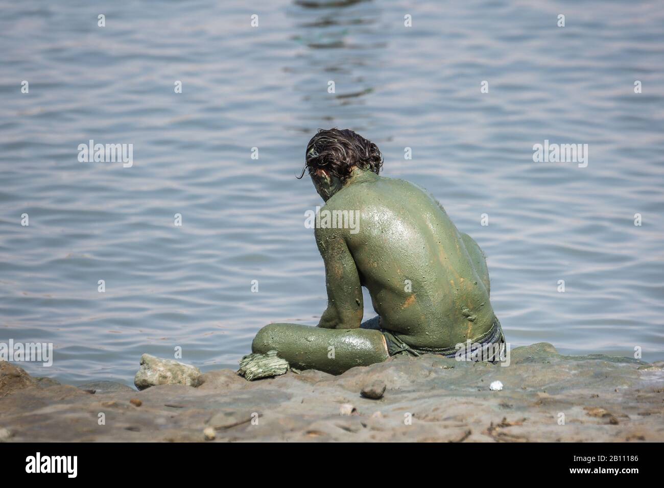 Tourists applying Dead Sea mud which possesses the medicinal qualities and helps to the people with skin problems. Body care treatment in Israel. Stock Photo