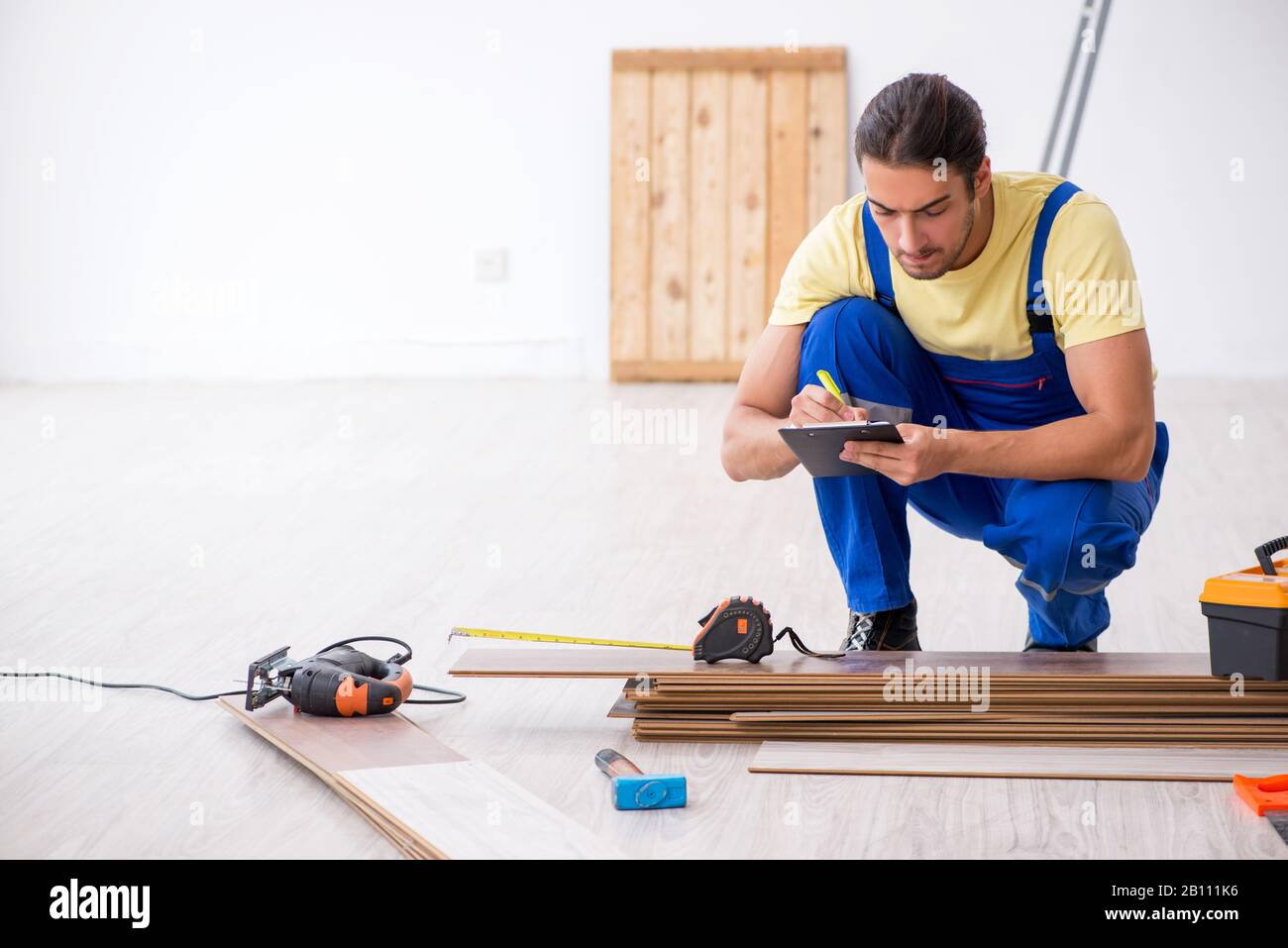 The young male contractor working indoors Stock Photo - Alamy
