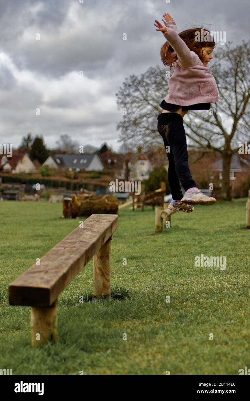 Girl playing in a park, jumping Stock Photo