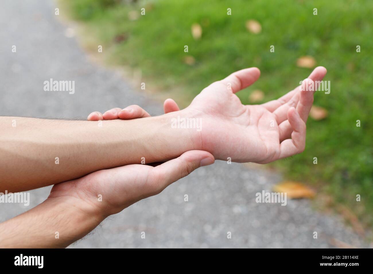 Closeup of male arms holding her painful wrist because exercise