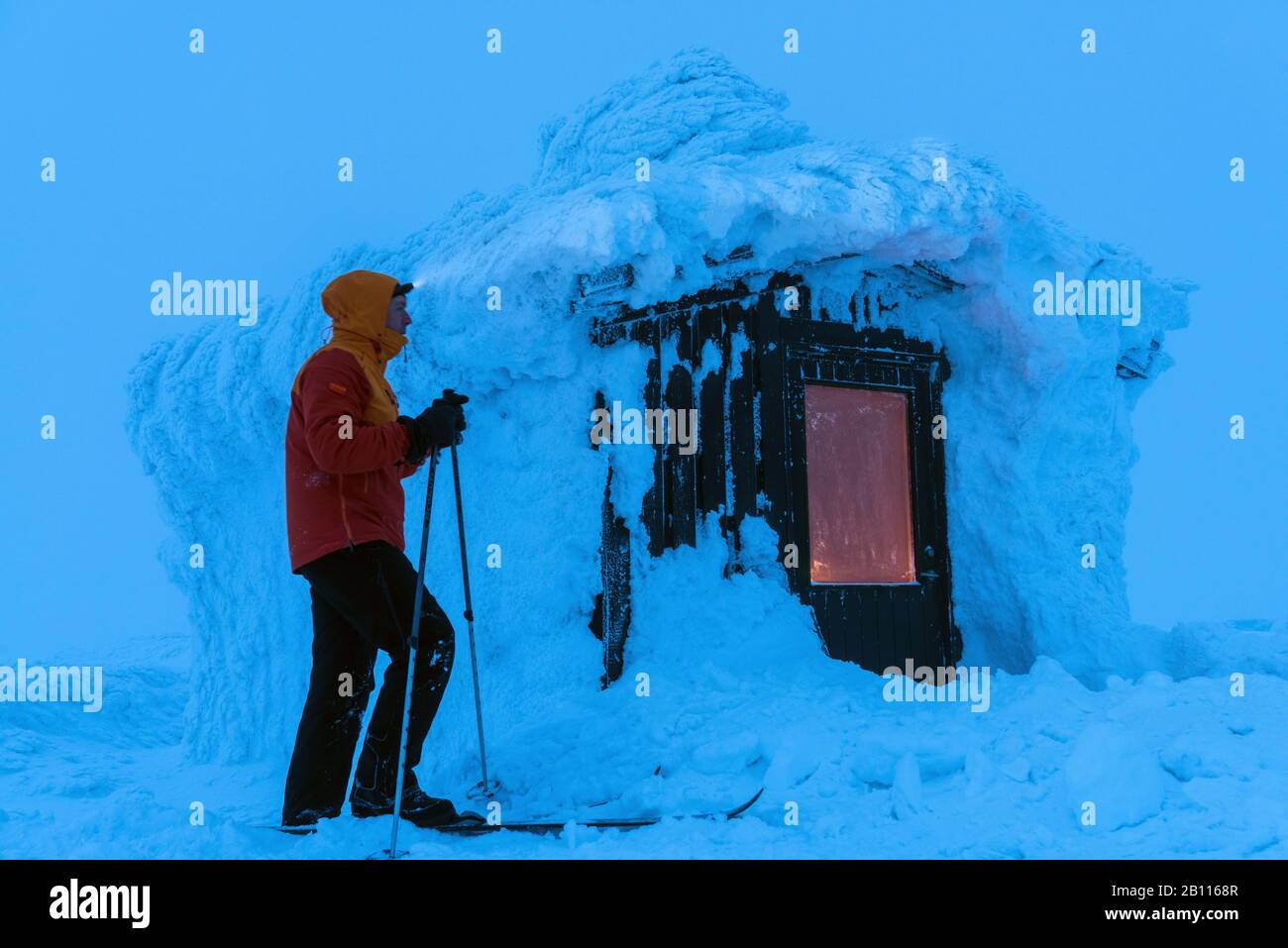 skier at a snow covered hut, Sweden, Lapland, Norrbotten, Dundret Naturreservat Stock Photo