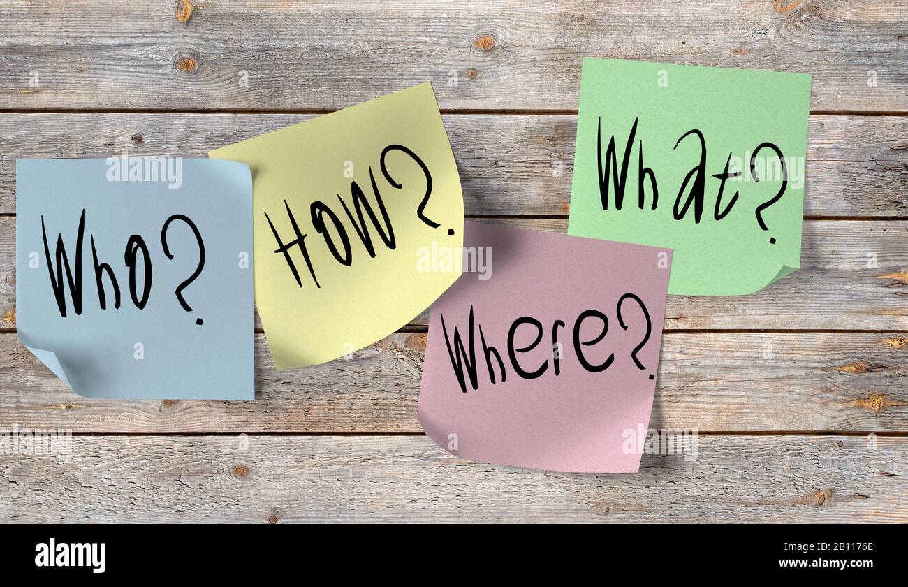 The questions who, where, what, how on sticky notes on a wooden wall ...