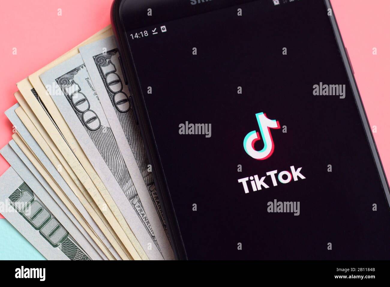 KHARKOV, UKRAINE - FEBRUARY 16, 2020: Tiktok application on samsung smartphone screen and dollar bills. TikTok is a popular video-sharing social netwo Stock Photo