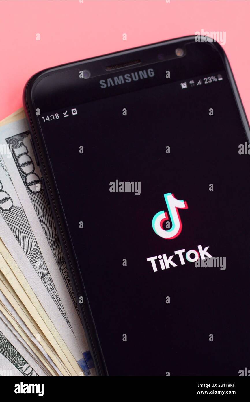 KHARKOV, UKRAINE - FEBRUARY 16, 2020: Tiktok application on samsung smartphone screen and dollar bills. TikTok is a popular video-sharing social netwo Stock Photo