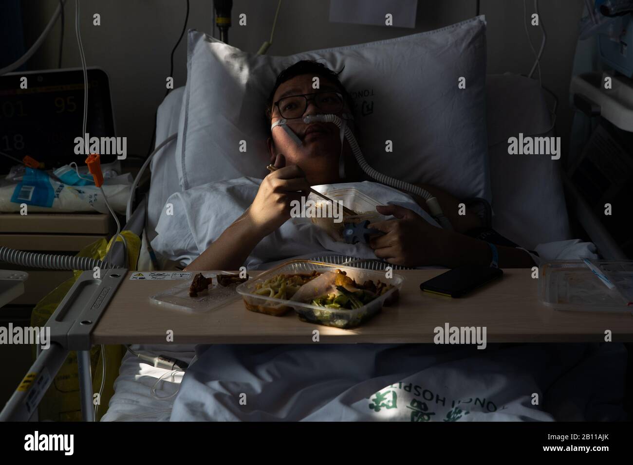 A Chinese patient eats lunch in the isolation ward at a hospital in Wuhan City, central China's Hubei Province on February 22nd, 2020. Stock Photo