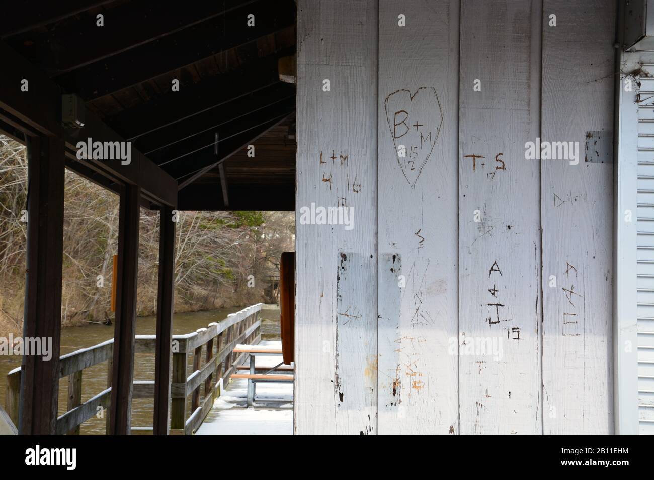 Graffiti is carved into the walls on the fishing dock at Shelley Lake Park in Raleigh North Carolina. Stock Photo