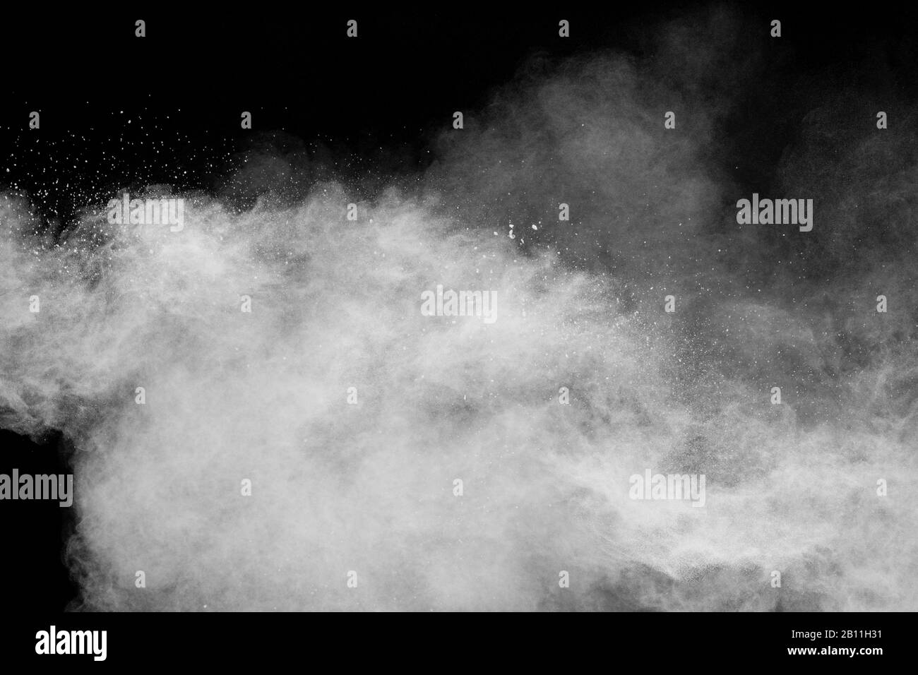 Freeze motion of white dust particles splash on black background.White powder explosion clouds. Stock Photo