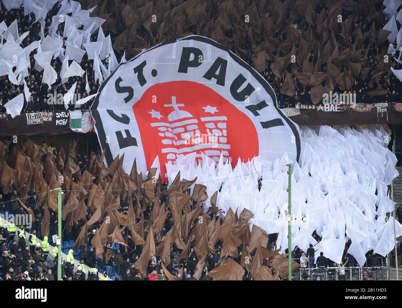 Hamburg, Germany. 22nd Feb, 2020. Football: 2nd Bundesliga, 23rd matchday: Hamburger SV - FC St.Pauli in the Volksparkstadion. The fans of FC St.Pauli hold flags and a large logo banner. Credit: Daniel Bockwoldt/dpa - IMPORTANT NOTE: In accordance with the regulations of the DFL Deutsche Fußball Liga and the DFB Deutscher Fußball-Bund, it is prohibited to exploit or have exploited in the stadium and/or from the game taken photographs in the form of sequence images and/or video-like photo series./dpa/Alamy Live News Stock Photo