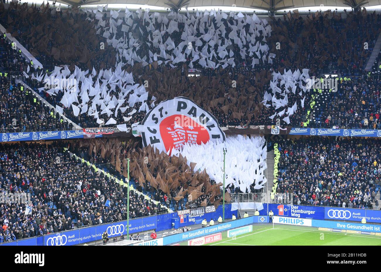 Hamburg, Germany. 22nd Feb, 2020. Football: 2nd Bundesliga, 23rd matchday: Hamburger SV - FC St.Pauli in the Volksparkstadion. The fans of FC St.Pauli hold flags and a large logo banner. Credit: Daniel Bockwoldt/dpa - IMPORTANT NOTE: In accordance with the regulations of the DFL Deutsche Fußball Liga and the DFB Deutscher Fußball-Bund, it is prohibited to exploit or have exploited in the stadium and/or from the game taken photographs in the form of sequence images and/or video-like photo series./dpa/Alamy Live News Stock Photo