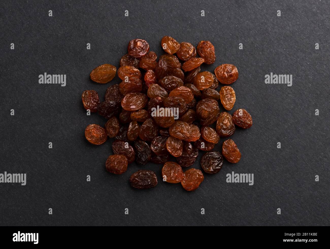 Pile of dried raisins on black background, top view Stock Photo