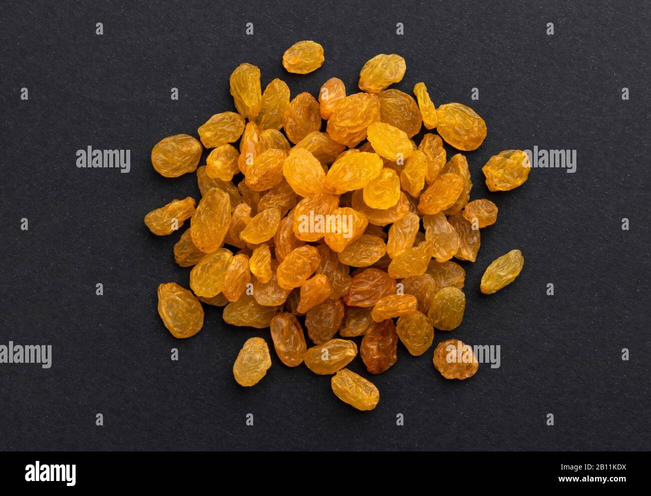 Pile of dried yellow raisins on black background, top view Stock Photo