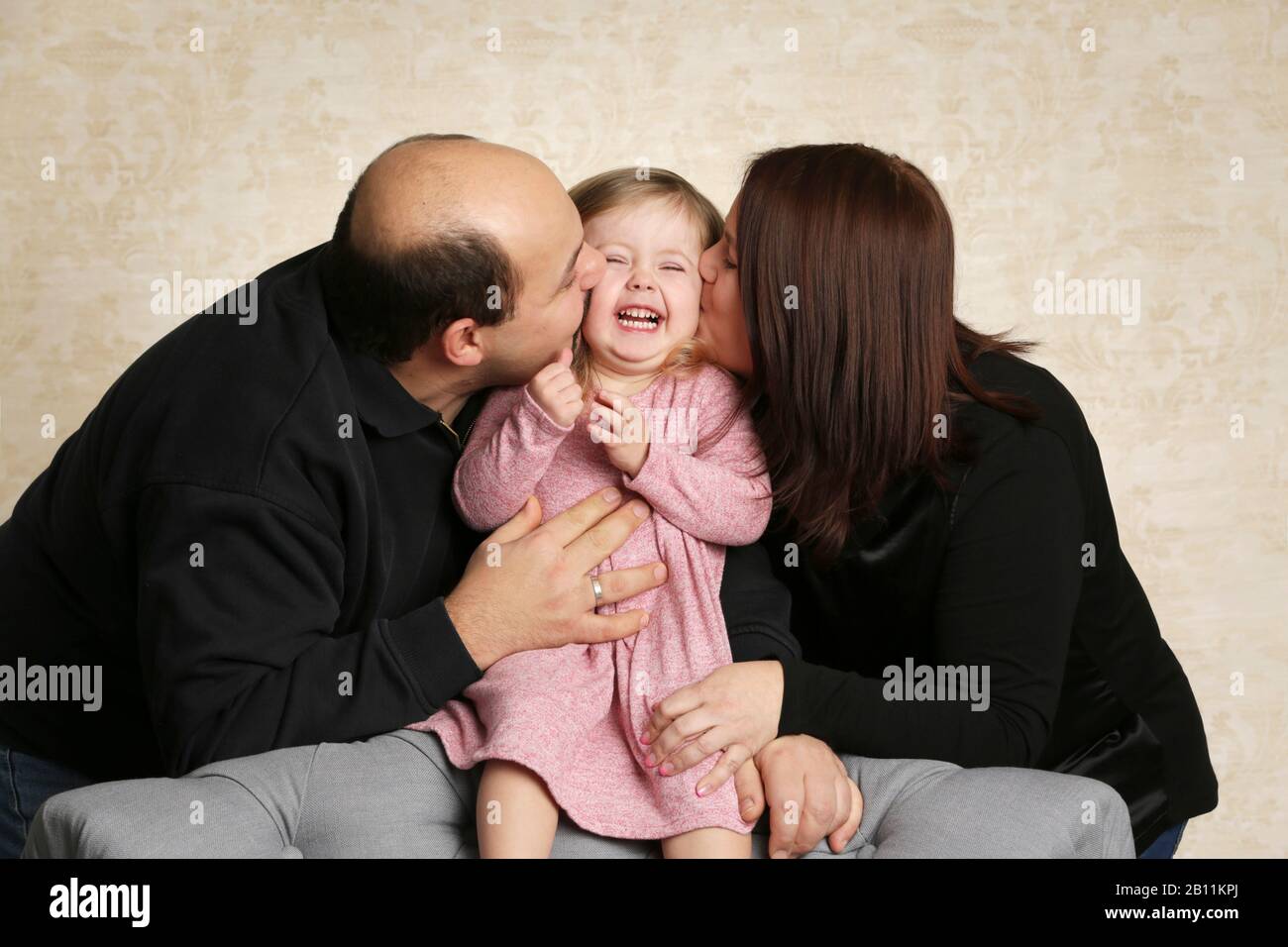 Parents kiss their child Stock Photo Alamy