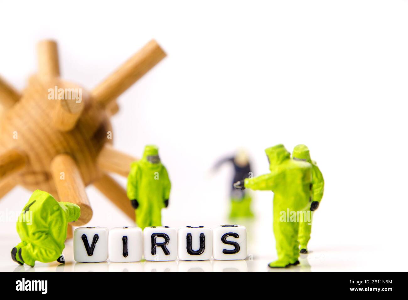 closeup of big corona virus with a team of special medical forces miniature figurines interfering during gas and other chemical accidents, the team pr Stock Photo