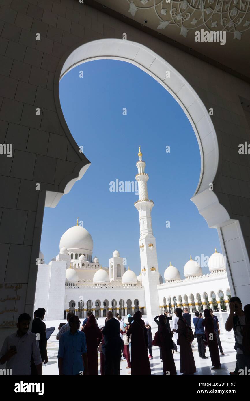 Brilliant white marble minaret and domes framed by an archway at the Sheikh Zayed Grand Mosque, Abu Dhabi Stock Photo