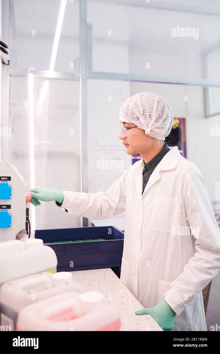Asian young scientist in white coat working with equipment in the laboratory Stock Photo