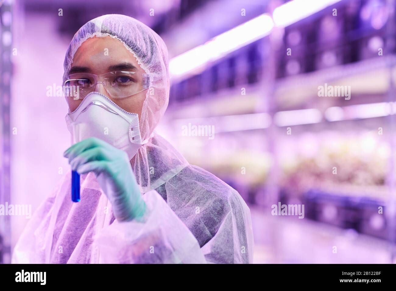 Portrait of Asian chemist looking at camera and holding test tube with analysis Stock Photo