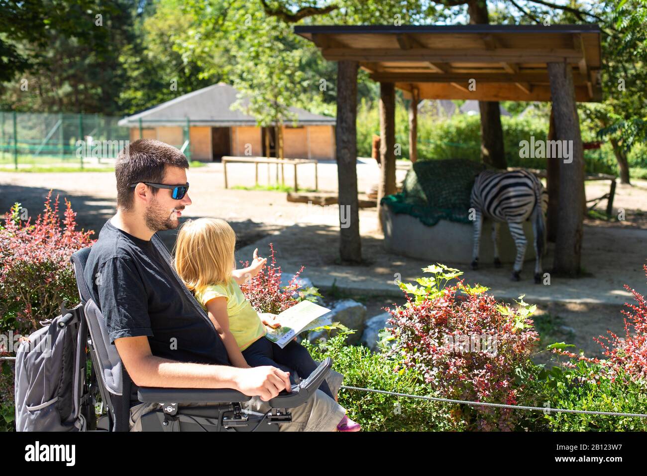 Disabled Father in Wheelchair enjoying Nature with Daughter Girl in