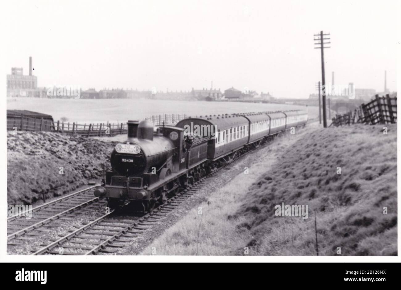 Vintage black and white photo of steam locomotive train - L.M. Ex L&Y Class 3F 0-6-0 52438 on the SLS / MLS Old Manchester rail tour near Royton 1956. Stock Photo
