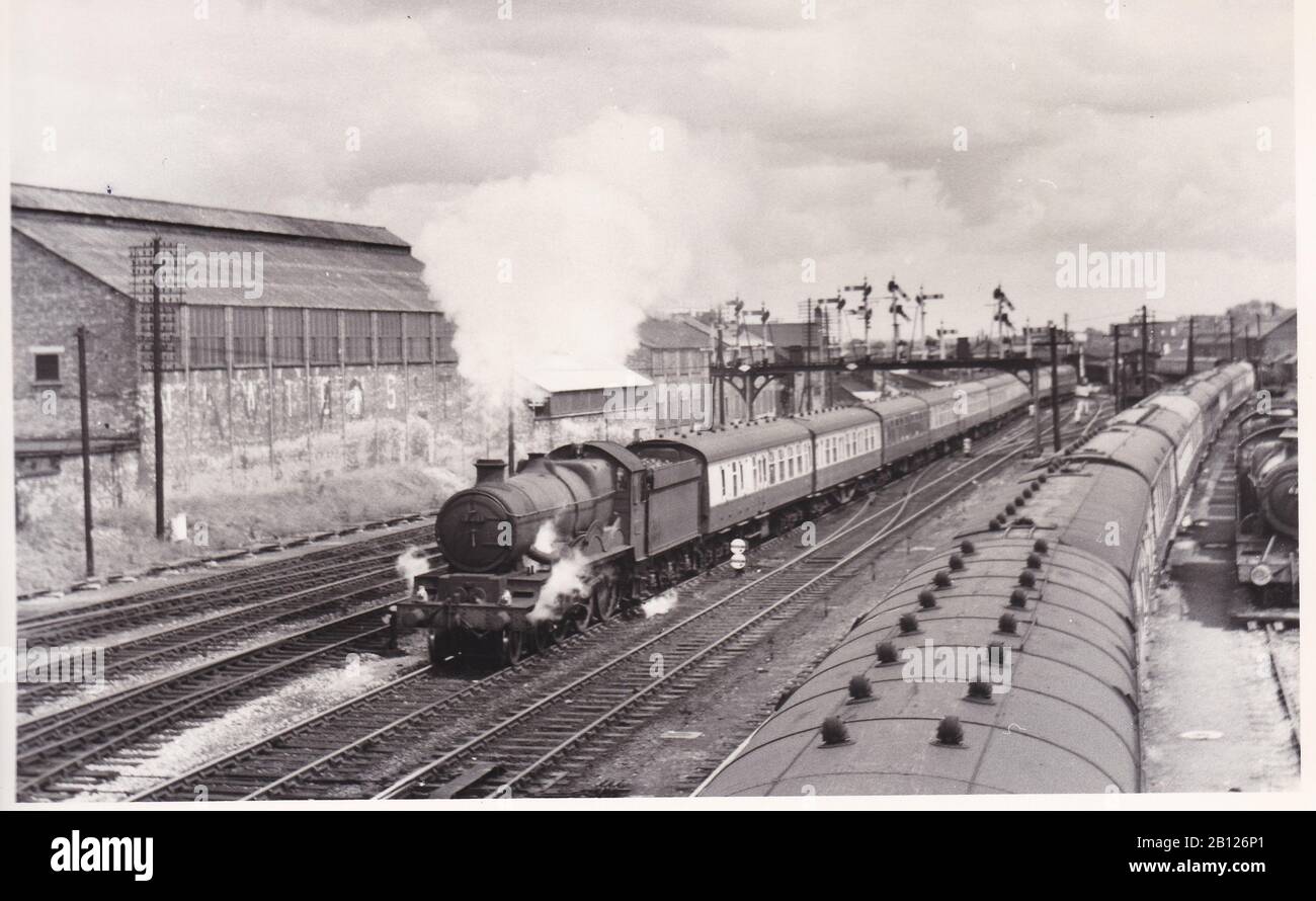 Vintage black and white photo of steam locomotive train - W.R. Castle Class 4-6-0 7011 Banbury Castle on a Down Express leaving Taunton Station 1959. Stock Photo