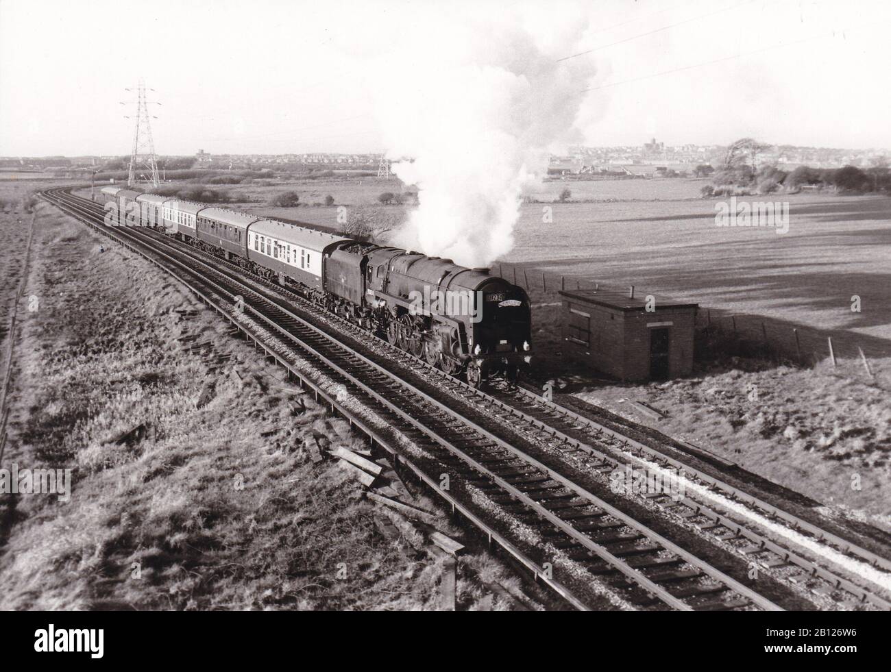 Vintage black and white photo of steam locomotive train - Headed by 9F 2.10.0 92058 R.C.T.S. Merseyside Branch rail tour approaching Bidsvon April 67. Stock Photo