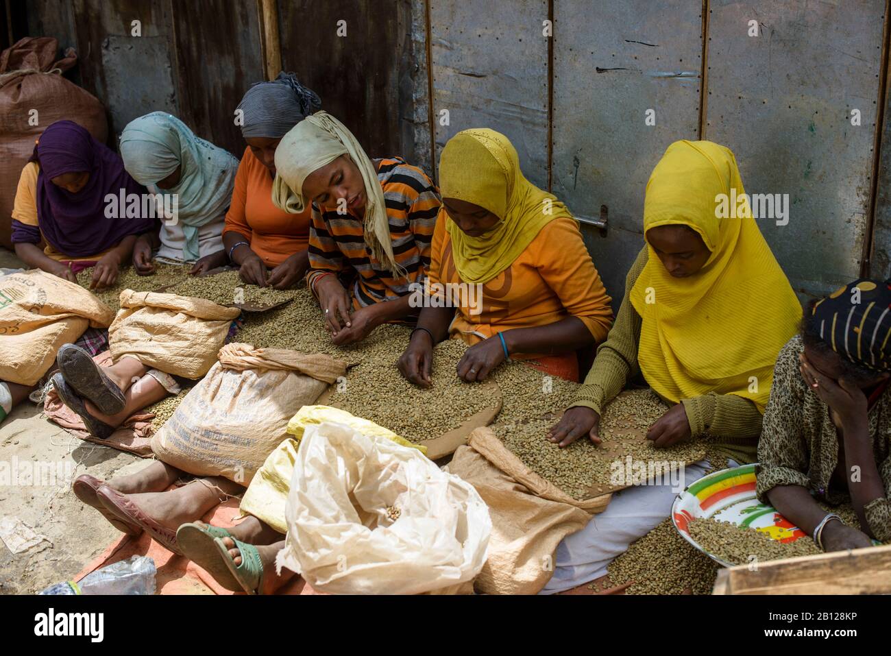 Muslim women sort coffee beans on the streets of the giant Mercato of Addis Ababa, Ethiopia Stock Photo