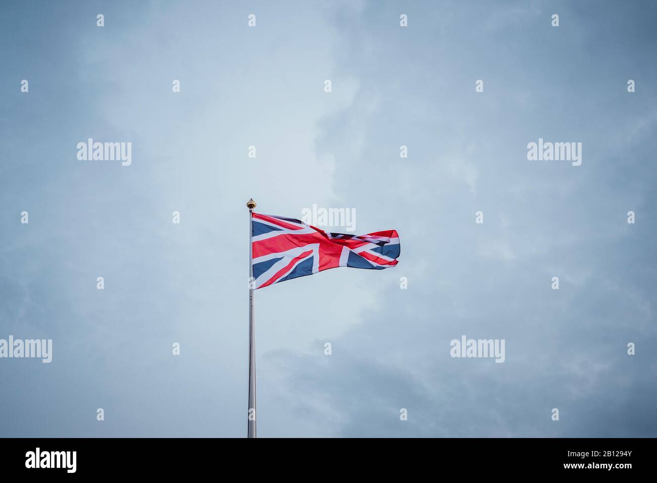 Waving flag in front of blue sky, United Kingdom | Waving flag in front of blue sky, United Kingdom Stock Photo