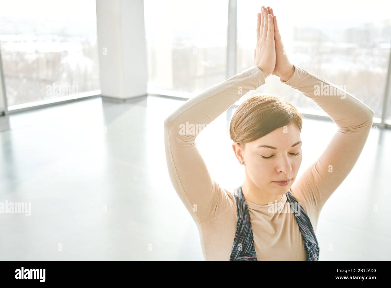 Pretty girl with her eyes closed keeping her hands put together over