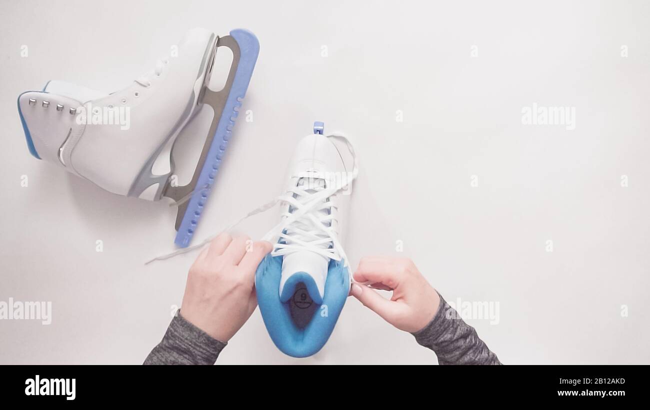 Flat lay. Lacing new white figure skates with white laces Stock Photo